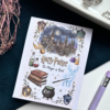 A7 Harry Potter wizarding world themed tear-off notepad with illustrated magical cover art, placed on a dark aesthetic desk surface with warm lighting