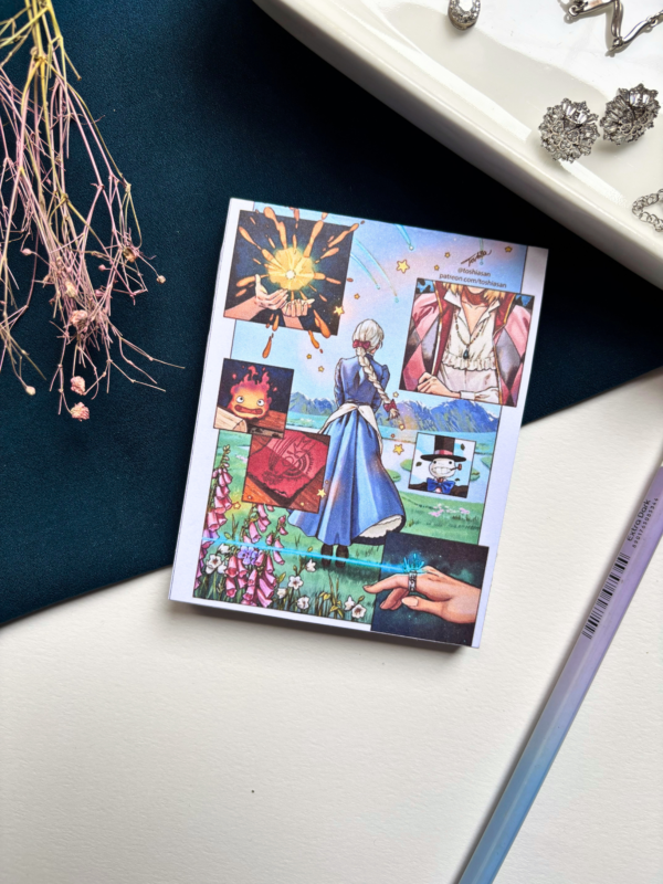 A7 Howl's Moving Castle Studio Ghibli tear-off memopad with illustrated cover art featuring the whimsical walking castle, placed on a warm aesthetic desk surface
