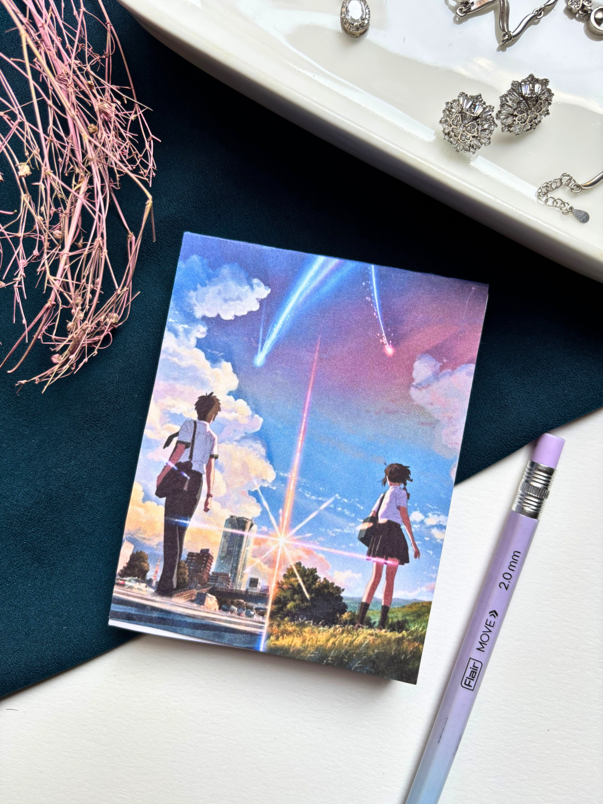 A7 Your Name Kimi no Na wa anime tear-off notepad with illustrated cover art featuring a twilight sky and comet, placed on a clean aesthetic desk surface