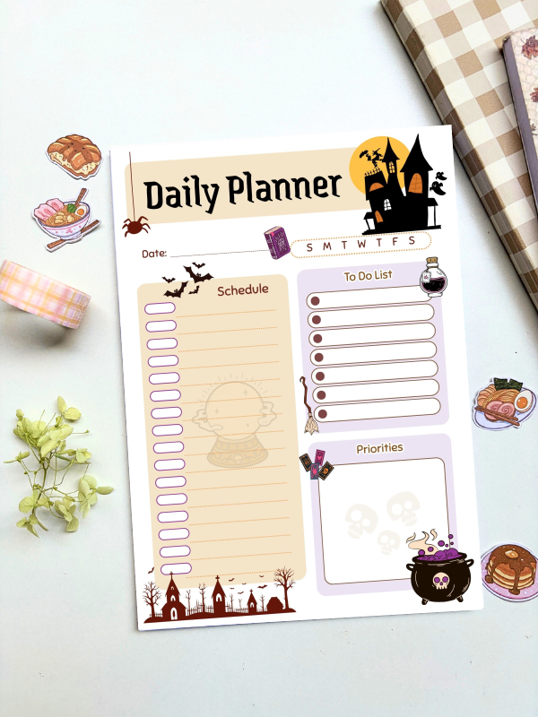 A5 daily planner with a witchy Halloween theme featuring a haunted house, crystal ball, cauldron, bats, and graveyard illustrations, with sections for schedule, to-do list, and priorities.