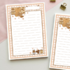 Lined notepad with a pink gingham border featuring a kitten holding a cocoa mug, chocolate bars, cocoa tin, iced coffee, and muffins, with a blank title label at the top.