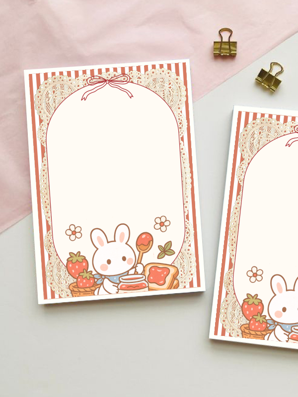 A6 notepad with a lace-bordered design featuring a cute bunny making strawberry jam toast, surrounded by strawberries and flowers, with a striped red border and bow.