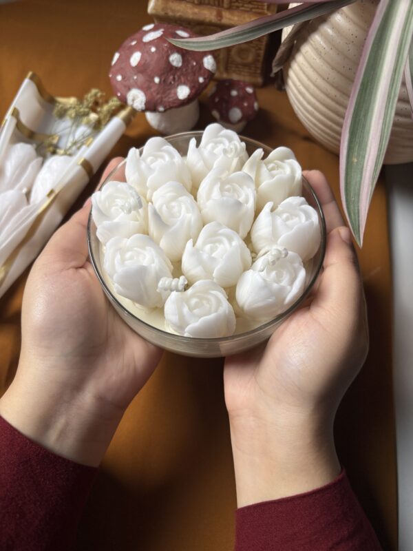 Handcrafted wide thali jar candle with a bunch of sculpted tulips, glowing softly on a table